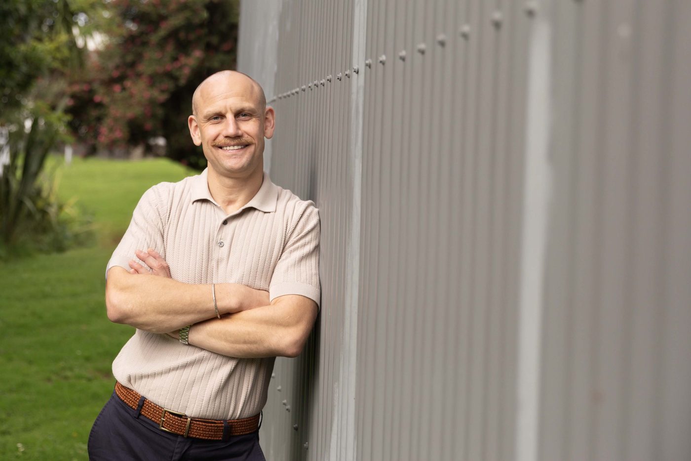 Jack, smiling, leaning on a wall outside